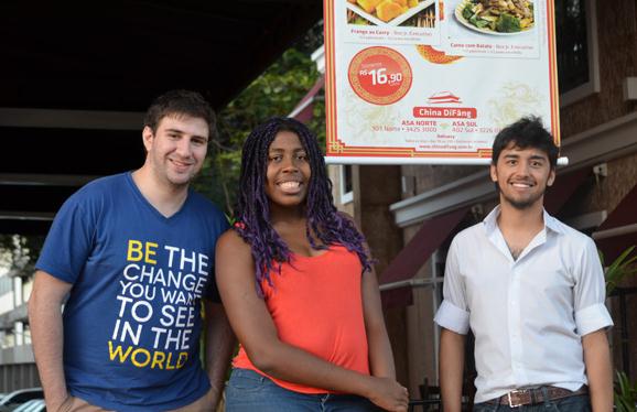Joao Casseb (left), Carla Xavier (middle) and Matt Oliveria, all Brazilian university students, pose before a Chinese restaurant in Brasilia. According to Oliveria, a student of the University of Brasilia, Chinese cuisine is popular among the local people, especially the youth. (Photo: China Daily/by Lia Zhu)