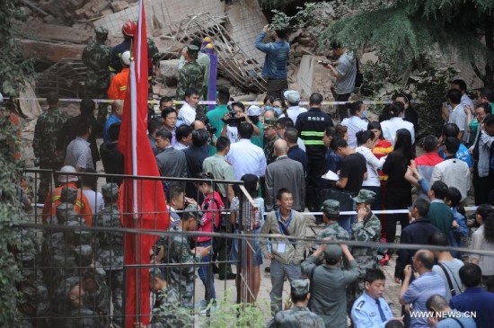 Rescuers search for survivors at a residential building collapse site in Guiyang, capital of southwest China's Guizhou Province, May 20, 2015. A nine-storey building collapsed in Guiyang on Wednesday. Rescuers have confirmed that there are people trapped inside, but casualties are not known yet. (Xinhua/Ou Dongqu)