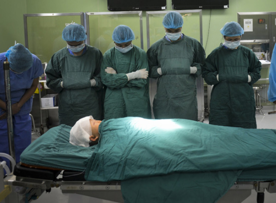 Doctors stand in tribute to 16-month-old Hanhan at West China Hospital in Chengdu, Sichuan province, on Feb 24. The boy was declared brain-dead after a traffic accident, and his parents decided to donate his organs to save lives. (Lyu Jia/for China Daily)