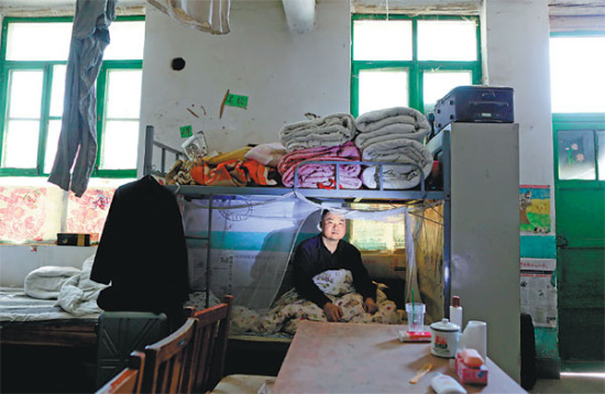 Zhuang Yizhan, a student at the Workers' College, awakens to prepare for school. The institute for young migrant workers provides free tuition, sleeping quarters and meals. (Photos by Feng Yongbin/China Daily)