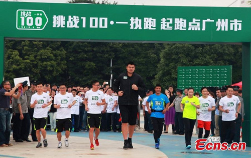 Former NBA player Yao Ming attends Chen Penbin's marathon challenge in Guangzhou, South Chinas Guangdong province, April 2, 2015. The former fisherman-turned-star runner plans to run 100 marathons in 100 consecutive days. Yao said Chen reminded him of the film Forrest Gump. (Photo: China News Service/Lv Ying)