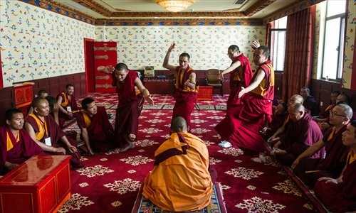 During a graduate exam for Nyingma sect lamas, a Tho Ram Pa program student (sitting in the center) of the High-level Tibetan Buddhism College of China is challenged by four Buddhist scripture debaters invited by the college from other temples to test the candidate. (Photo: GT/Li Hao)