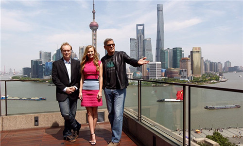 Tomorrowland star George Clooney (right) poses with director Brad Bird and actress Britt Robertson on the Bund yesterday as they arrived in the city for a press conference for the Disney film that will premiere on the Chinese mainland on May 26. (Photo/Shanghai Daily)