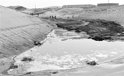 The undated photo shows one pit containing waste liquid in the Tengger Desert. The waste water was secretively transferred to the Tengger Desert by entreprises. (Photo/ce.cn)