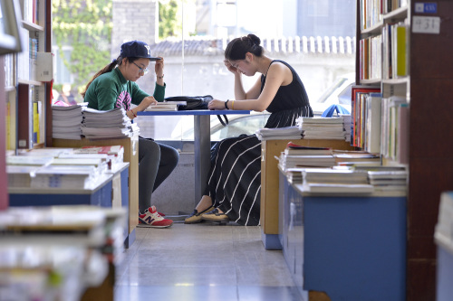 People read in the newly opened branch of Sanlian Taofen Bookstore in Beijing. The opening of 24-hour bookstore has been welcomed by the students and residents nearby (XINHUA) 