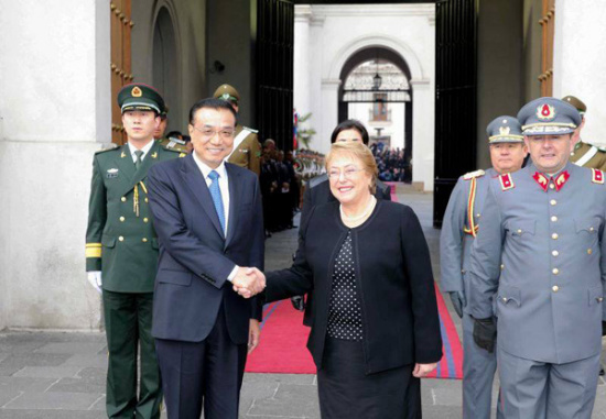Premier Li Keqiang is welcomed by Chilean President Michelle Bachelet at the presidential palace in Santiago on May 25. The two leaders also watched a parade of honor guards.[Photo / english.gov.cn]
