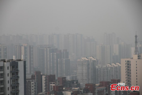 Buildings are seen amid the heavy smog in Beijing, capital of China on Saturday,January 3, 2015. According to statistics from China's Ministry of Environmental Protection, the air quality index was 186, and the level of PM2.5 was 142 as of 9 am, signaling moderate pollution. [Photo: China News Service/ Liu Xianguo]