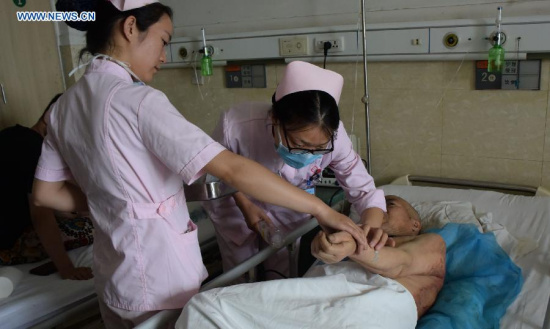 An elder receives treatment at a hospital in Lushan County of Pingdingshan City, central China's Henan Province, May 26, 2015. Thirty-eight people were killed and six others injured in a fire at a rest home in Lushan on Monday night. (Xinhua/Zhao Peng)