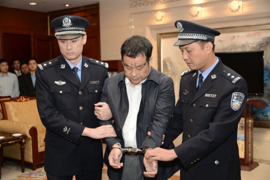 Policemen escorts Li Huabo, the second suspect from China's 100 most wanted economic fugitives list, after he was repatriated from Singapore on May 9, 2015, as part of operation Sky Net. (Photo/ccdi.gov)