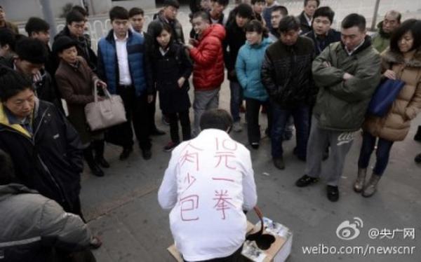 To raise money for his ill son, Xia Jun advertises himself as a human punch bag outside a subway station, charging 10 yuan (U.S.$1.6) for per punch.