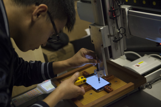 A young maker tests the sensitivity of a smartphone screen with a self-developed robot arm in Shenzhen. The city has become an innovation hub and enticed a special breed of talent with big ideas to match. Photo/China Daily