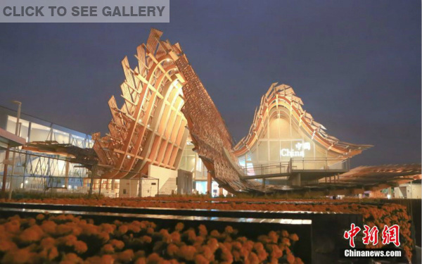 The photo shows the night view of the China Pavilion at the Expo Milano 2015. The China Pavilion is a self-built pavilion with a wave-like, timber-framed roof. The Pavilion, integrating with both aesthetic design and high technology, illustrates and explains in detail China's philosophies on agriculture, food, eating and nature. (Photo/Chen Jian)