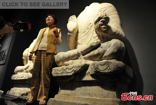 Liu Jianhua, a member of the National Committee of Cultural Relics Identification, presents a headless Buddha statue at Hebei Museum in Shijiazhuang, capital of North China's Hebei province, May 4, 2015. The white marble statue, built in 556, will be moved to Taiwan and reunited with its head, lost 18 years ago, thanks to coordination by Taiwan's famous monk Grand Master Hsing Yun. Hebei Musuem will also present 77 valuable cultural relics items from the province on the island. (Photo: China News Service/Zhai Rujia)
