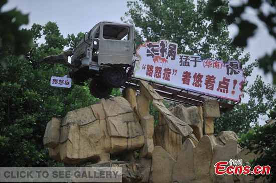 A structure depicting a car accident has been built at the entrance of the Foreigner Street theme park in Southwest China's Chongqing municipality to warn against bad driving habits. The structure has slogans that mean 