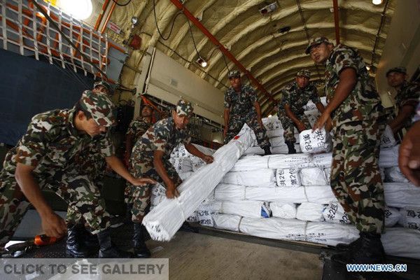 Members of Nepalese Army shift relief materials and equipment for earthquake-affected Nepalese people to a truck at Tribhuvan International Airport in Kathmandu, Nepal, on May 20, 2015. (Photo: Xinhua/Pratap Thapa) 