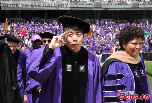 Chinese pianist Lang Lang receives an honorary doctorate presented by John Sexton, President of New York University, at NYU's 183rd Annual All-University Commencement in Yankee Stadium in New York, May 20, 2015. The honor was in recognition of Lang Lang's contribution to promoting classical music. (Photo: China News Service/Ruan Yulin)
