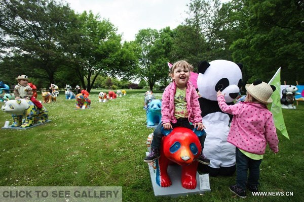 Children play around colorful panda sculptures and a staff member wearing panda costume during the "Experience China" event at the Gardens of the World in Berlin, Germany, on May 21, 2015. (Photo: Xinhua/Zhang Fan) 