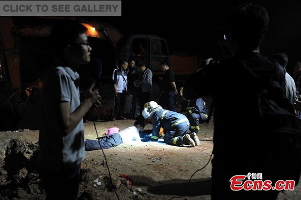 Rescuers try to help a two-year-old boy out of a deep well in Xi'an city, capital of Northwest China's Shaanxi province, May 21, 2015. The boy fell into the well, which is about 30 meters deep and has a diameter of 40 centimeters, on Thursday night. The boy, who was still trapped as of Friday morning, was heard calling for his mother and father by a recording device. (Photo/CFP)