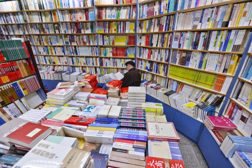 A customer reads in Sanlian Taofen Bookstore on April 23, World Book Day (XINHUA) 