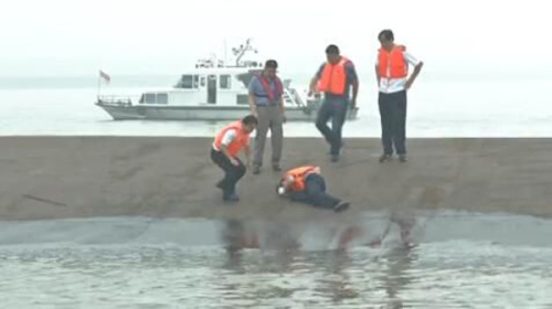 Rescuers listen for sounds of life inside the capsized ship. (Photo: CCTV/Twitter)