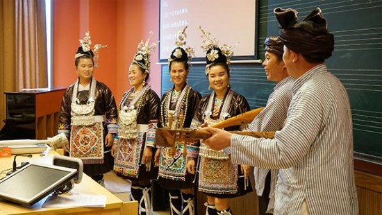 Members of the choral group Dong Singers, clad in traditional attire, host an interactive session with students of Shanghai Conservatory of Music. Photo provided to China Daily  