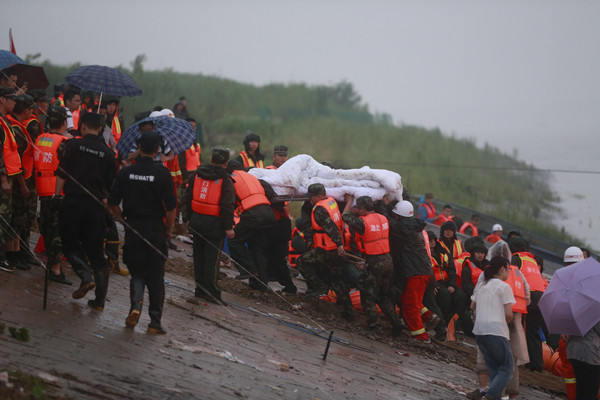 Rescue workers transport the body of a victim of the capsized Eastern Star on Tuesday. (Photo by Feng Yongbin/China Daily)