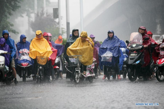 Residents wait for traffic lights in rain at a crossing in Nanjing, capital of east China's Jiangsu Province, June 2, 2015. The National Meteorological Center issued a yellow warning for torrential rain across the middle and lower reaches of Yangtze River on Tuesday. (Xinhua/Yan Minhang)