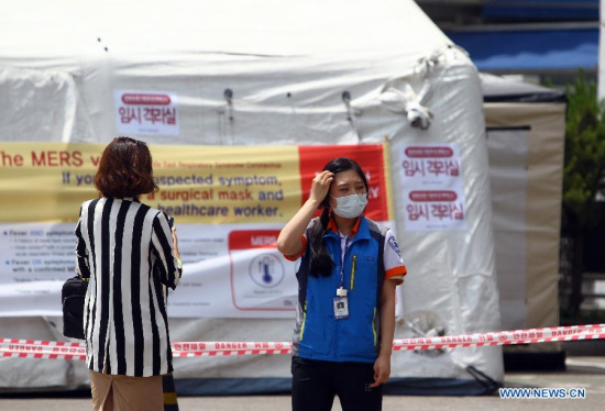 A medical worker (R) stands in front of a quarantine tent for people who may be infected with the virus causing MERS at Seoul National University Hospital in Seoul, South Korea, on June 2, 2015. Fears for the Middle East Respiratory Syndrome (MERS) reached a peak in South Korea as the first two deaths and tertiary infection were reported Tuesday. (Photo: Xinhua/Yao Qilin)