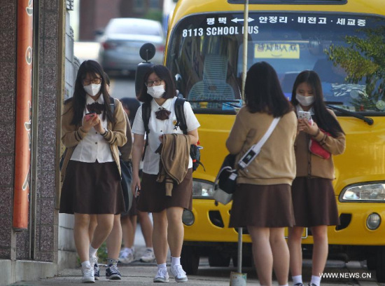 Girls wearing face masks walk homes after school in Pyeongtaek, South Korea, June 3, 2015. More than 200 schools in South Korea have suspended classes Wednesday due to fears for contagion of young students from the deadly Middle East Respiratory Syndrome (MERS). (Xinhua/Yao Qilin)