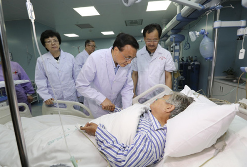 Premier Li Keqiang talks with Zhu Hongmei at the hospital. (Photo/China News Service)