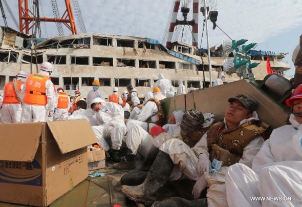 Rescuers take a rest on the bank where Eastern Star, the passenger ship capsized by a tornado, is berthed in the section of Jianli on the Yangtze River, central China's Hubei Province, June 6, 2015. (Photo/Xinhua)