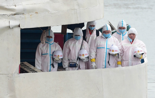 Rescue workers bow their heads during the mourning ceremony on Sunday. (Photo: Cheng Min/Xinhua)