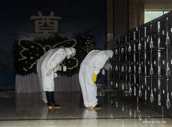 Encoffiners bow to the victims of the capsized ship accident before the body make-up at the funeral parlour in Jianli, central China's Hubei Province, June 9, 2015. Local encoffiners held encoffination ceremonies Tuesday for victims of the capsized ship Eastern Star, which was carrying 456 people onboard on an 11-day trip along the Yangtze River when it was overturned by a tornado on June 1 in Jianli. (Xinhua/Xiao Yijiu)