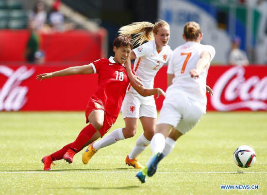 China's Han Peng (L) vies with Desiree Van Lunteren (C) of the Netherlands during the group A match against the Netherlands at the 2015 FIFA Women's World Cup in Edmonton, Canada, June 11, 2015. (Xinhua/Ding Xu)