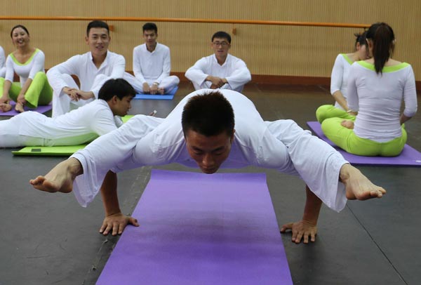 Students do yoga in Yunnan University of Nationalities in Kunming. The university established the country's first yoga college on Saturday and the college will start enrolling students in August. Provided to China Daily