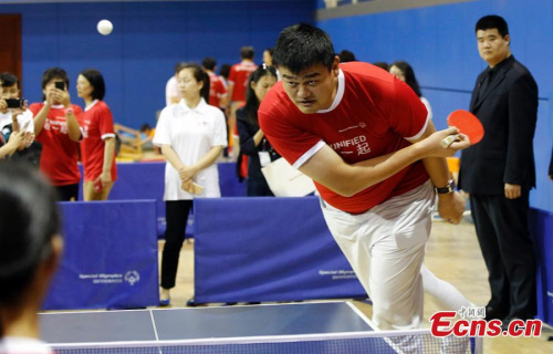Former NBA star Yao Ming plays table tennis with Special Olympics athletes during an event in Shanghai, June 12, 2015. (Photo: China News Service/Tang Yanjun)