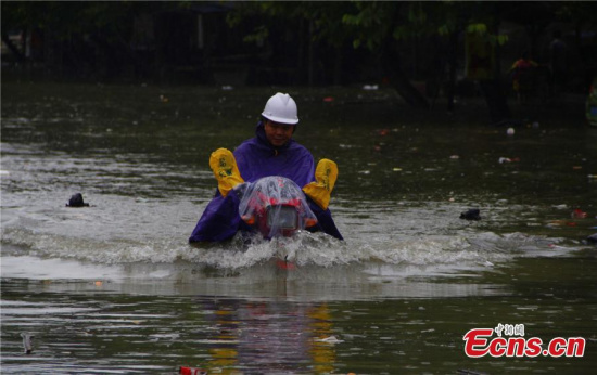 A motorcyclist braves floods on a street in Liuzhou city, Southwest Chinas Guangxi Zhuang autonomous region, June 11, 2015. (Photo: China News Service/Zhu Liurong)