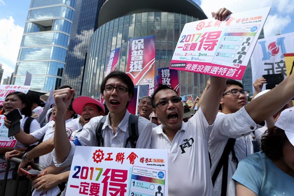 Citizens carry placards and shout slogans outside the Legislative Council headquarters in Admiralty district to support the Hong Kong government's electoral reform package on Wednesday. (Roy Liu / China Daily)