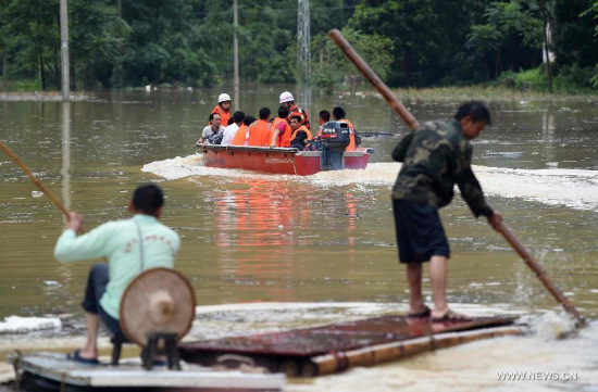 Rescuers help evacuate local residents in Deli Village of Dahua Yao Autonomous County, south China's Guangxi Zhuang Autonomous Region, June 14, 2015. (Photo: Xinhua/Huang Xiaobang)