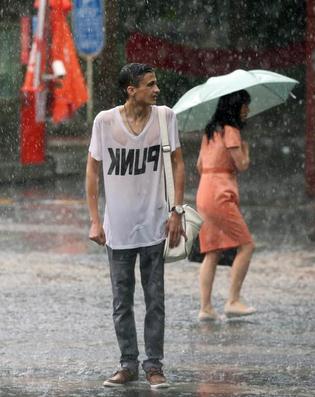 A man stands drenched through with rain in Beijing on Wednesday. (Photo: Wang Jing/China Daily)