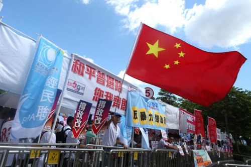 Citizens carry placards and national flags outside the Legislative Council headquarters in Admiralty district to support the Hong Kong government's electoral reform package on June 17, 2015. (Roy Liu/China Daily)