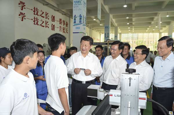 President Xi Jinping chats with a student during a visit to Guizhou Machinery Vocational School in Guiyang, the provincial capital, on Wednesday. He described vocational education as an important part of the country's education system and called for it to be continually improved. The president toured the province from Tuesday to Thursday. LI XUEREN / XINHUA