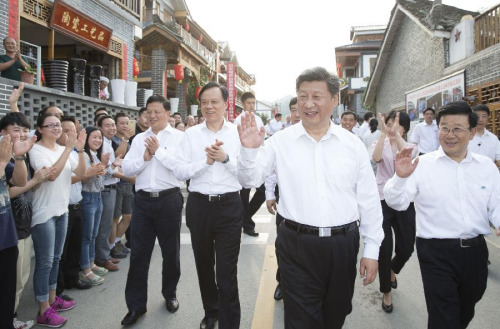 Chinese President Xi Jinping (front) waves to people at Huamao Village of Fengxiang Township in Zunyi County, southwest China's Guizhou Province, June 16, 2015. Xi had an inspection tour in Guizhou Province from June 16 to 18. (Xinhua/Huang Jingwen)