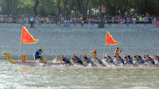 Participants compete in a dragon boat race to mark the Dragon Boat Festival, in Harbin, capital of northeast China's Heilongjiang Province, June 20, 2015. (Photo: Xinhua/Liu Yang) 