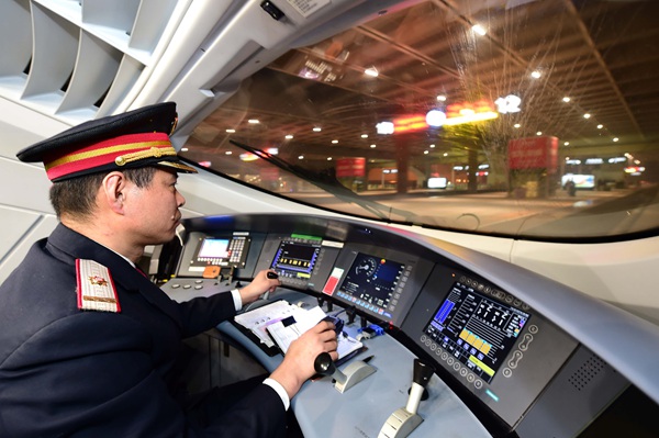 Xue Jun drives a bullet train heading to Beijing South Railway Station in February. (GUO XULEI/XINHUA NEWS AGENCY)