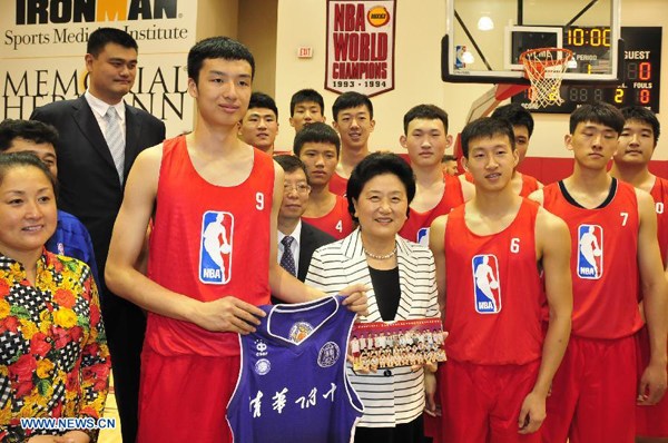 Chinese Vice Premier Liu Yandong (C) poses for group photos with Chinese student athletes from Tsinghua High School, during a visit to NBA basketball team Houston Rockets' home field Toyota Center in Houston, the United States, on June 21, 2015. Chinese Vice Premier Liu Yandong on Sunday called for more basketball diplomacy activities to strengthen mutual understanding and friendship between the Chinese and American peoples. (Xinhua/Zhang Yongxing)