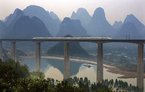 A high-speed train crosses a bridge in Yangshuo in the Guangxi Zhuang autonomous region. China's longest high-speed railway service, which links Beijing and Nanning, capital of the Guangxi, is 2,489 kilometers in length. (Photo/China Daily)