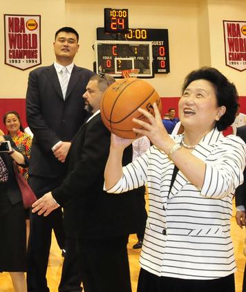Vice-Premier Liu Yandong shoots for the hoop at NBA basketball team Houston Rockets' home court Toyota Center watched by former Rockets star Yao Ming. (Photo/Xinhua)