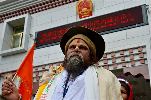 An Indian pilgrim goes through the Nathu La Pass at the Chinese border on Monday. A group of more than 40 Indian pilgrims will visit a sacred mountain and lake in China's Tibet. (Photo/Xinhua)