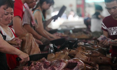 Vendors in Yulin, Guangxi Zhuang Autonomous Region cut dog meat for sale on Monday. (Photo: Cui Meng/GT)